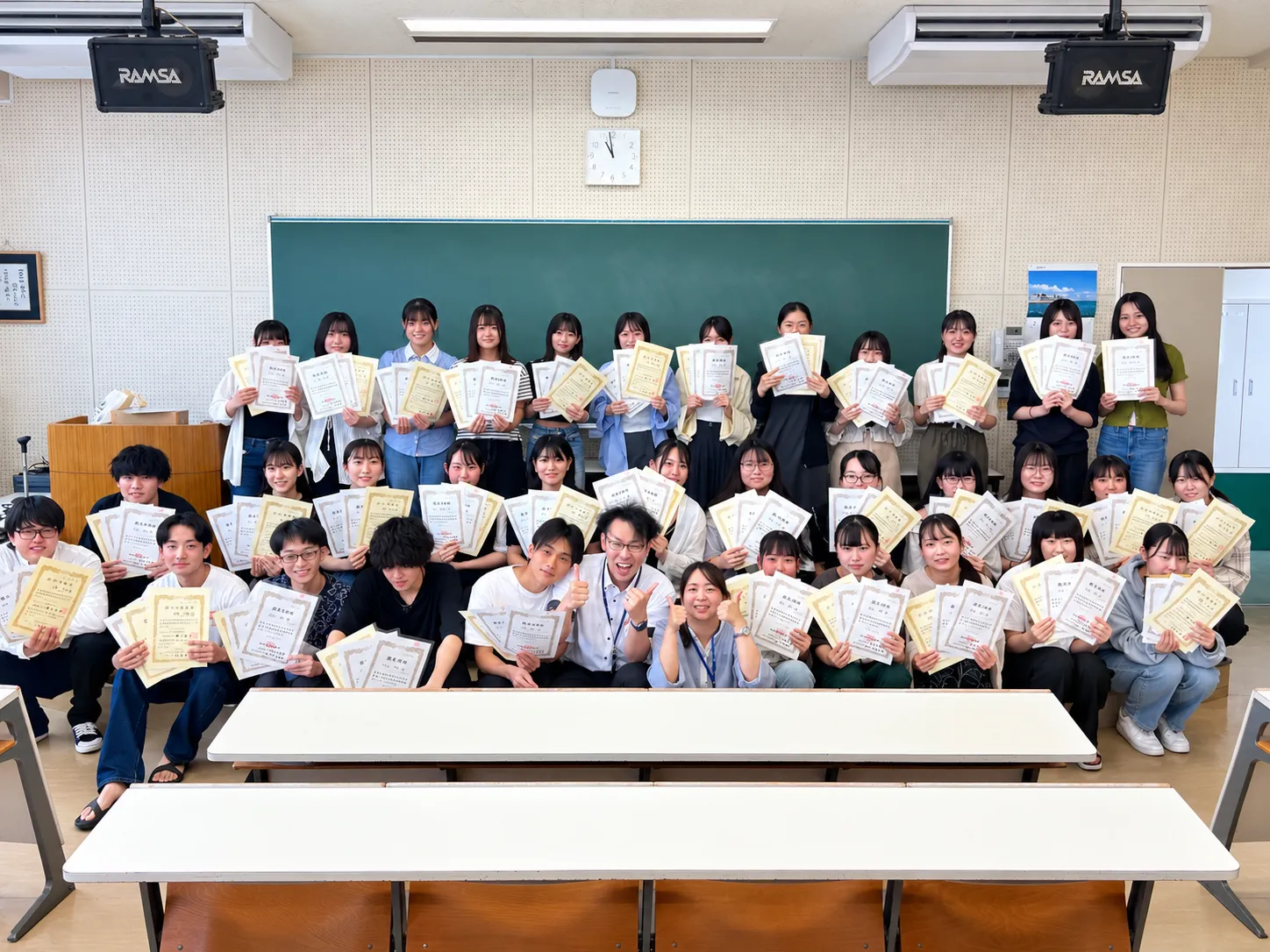 資格取得の成果を賞状とともに喜ぶ学生たちの集合写真