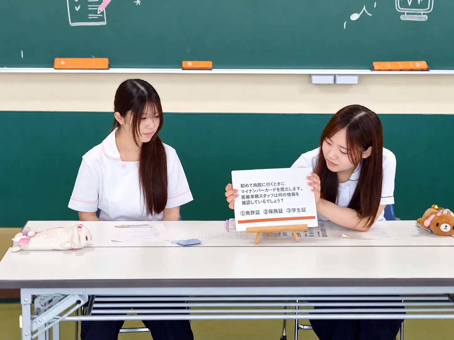 医療事務に関するクイズを紹介する学生2人